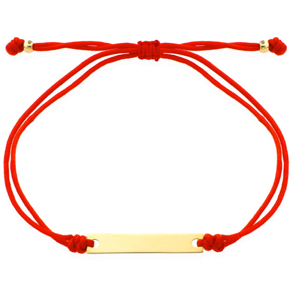 O brățară de aur cu o placă gravată pe un șnur roșu